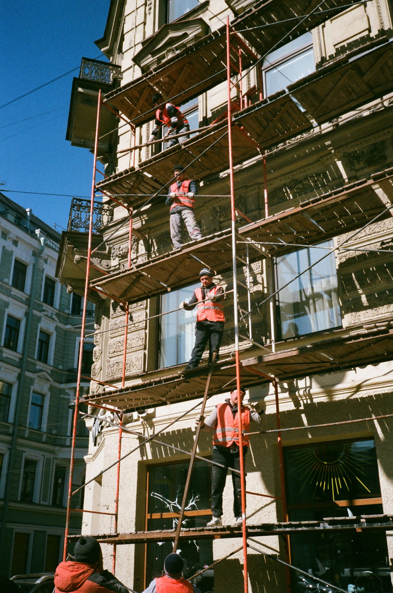 Workers on scaffolding carrying out facade refurbishment of a period building
